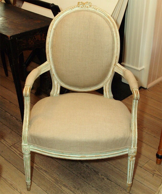 Painted Louis XVI Fauteil with hint of pale green in the paint finish.  Oval Back has check fabric on the very back of chair.  Ribbon detail on top of chair.
