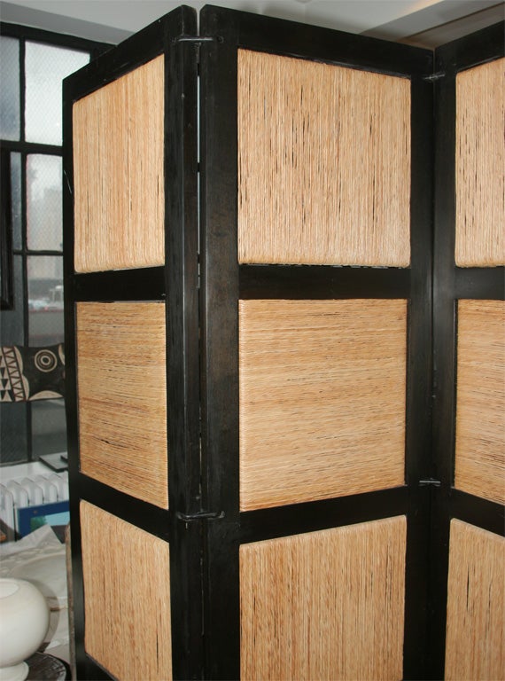 A four-panel screen designed by Vicente Wolf. Dark wood frame encasing woven hemp panels. 69
