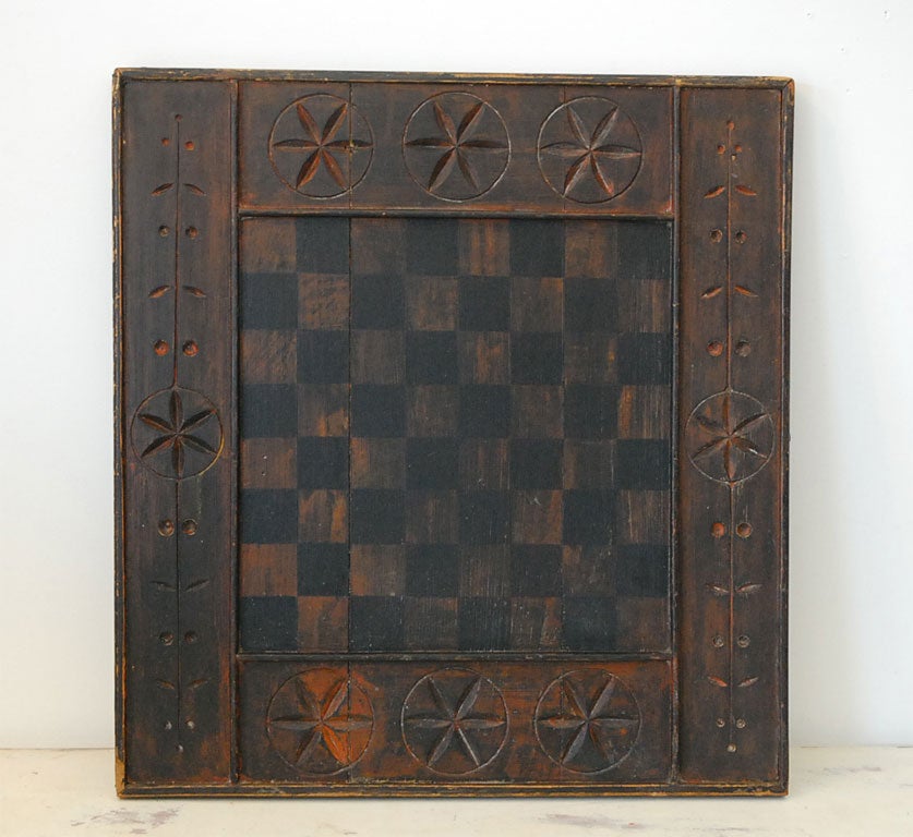 19THC ORIGINAL HAND CARVED AND PAINTED GAMEBOARD WITH ORIGINAL SURFACE GREAT CONDITION  FOUND IN PENNSYLVANIA. VERY FOLKY DETAILS TO THE FRONT SIDE CORNERS.