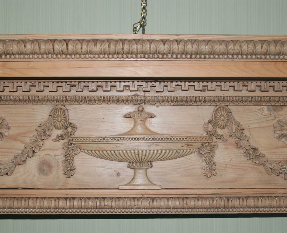 George III carved pine chimney mantle piece, the frieze carved with urns, flowerheads and swags. English, circa 1780. 

Measures: Height 57 1/2