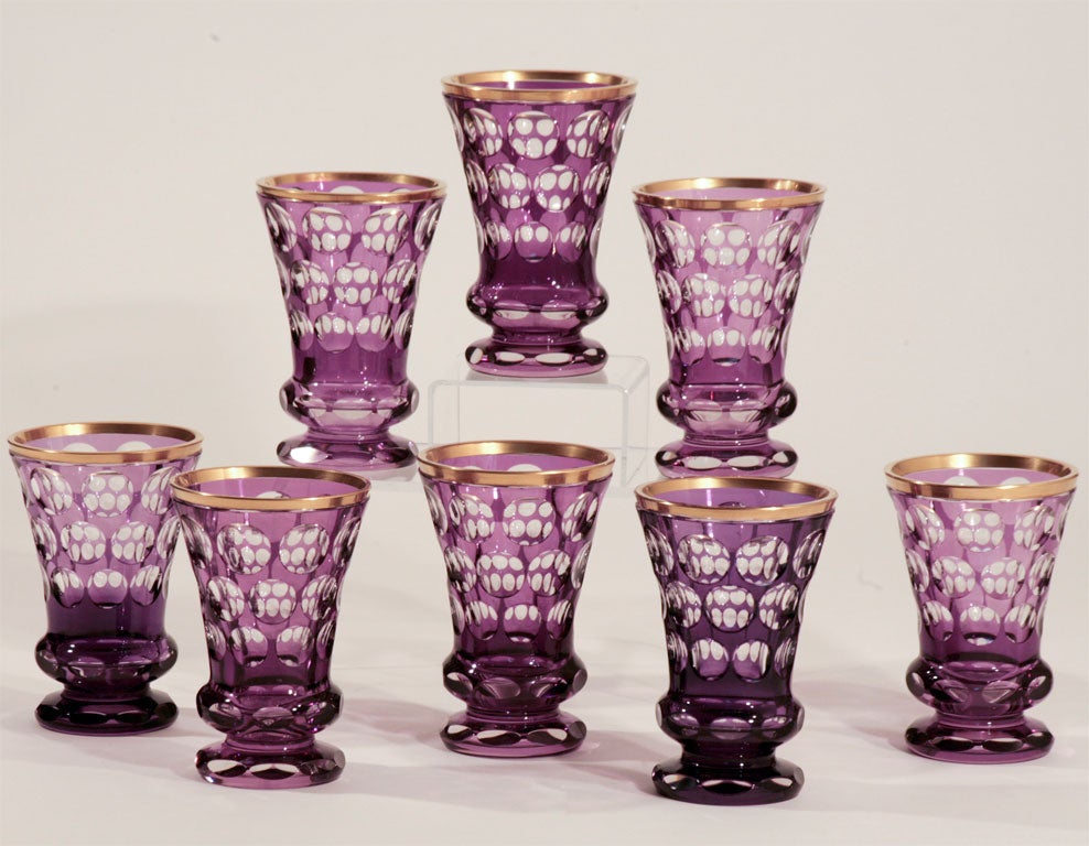 This is an amazing matched set of 8 Bohemian crystal footed vases. Hand blown with amethyst overlay and cut to clear with facet cutting around the foot and waist. The rims are further embellished with gold and would make a fabulous center