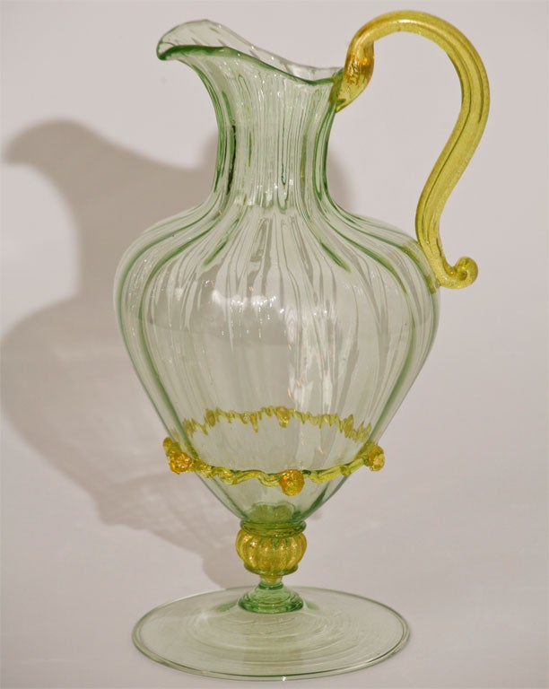 An elegant tall Venetian handblown pitcher stands alone as a sensuous sculptural piece. The apple green contrasts beautifully with the applied lemon yellow handle, connector and rigaree. Attributed to Saviati, this is both a practical and decorative