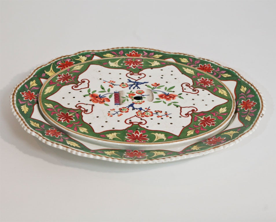 This is an amazingly large meat platter with hand painted chinoiserie-style polychrome enamel decoration. The 2-piece set includes the rare matching strainer/drainer. The platter has a gadroon border and gold trim; with the bright red contrasting