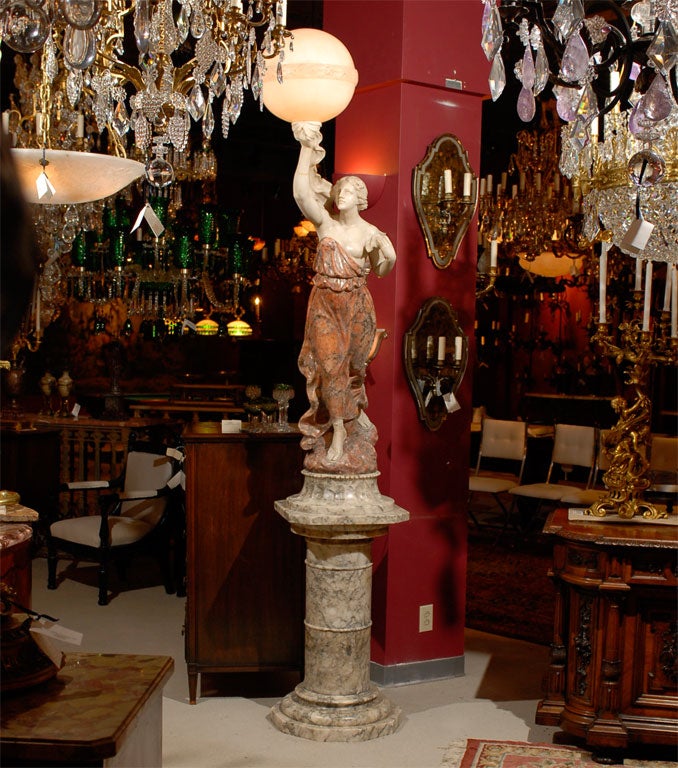 A magnificent and unique statue of a maiden in two tone alabaster over mottled alabaster pedestal holding aloft a lighted shade