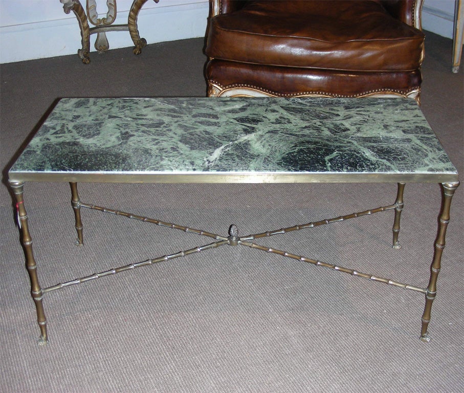 1950s coffee table with base in gilt bronze with X-shaped stretcher, clawed legs and veined green marble top.
