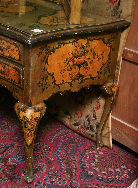 Venetian painted vanity and mirror, having a tri-fold mirror with painted foliage over the table with a drawer flanked by two smaller drawers raised on cabriole legs.