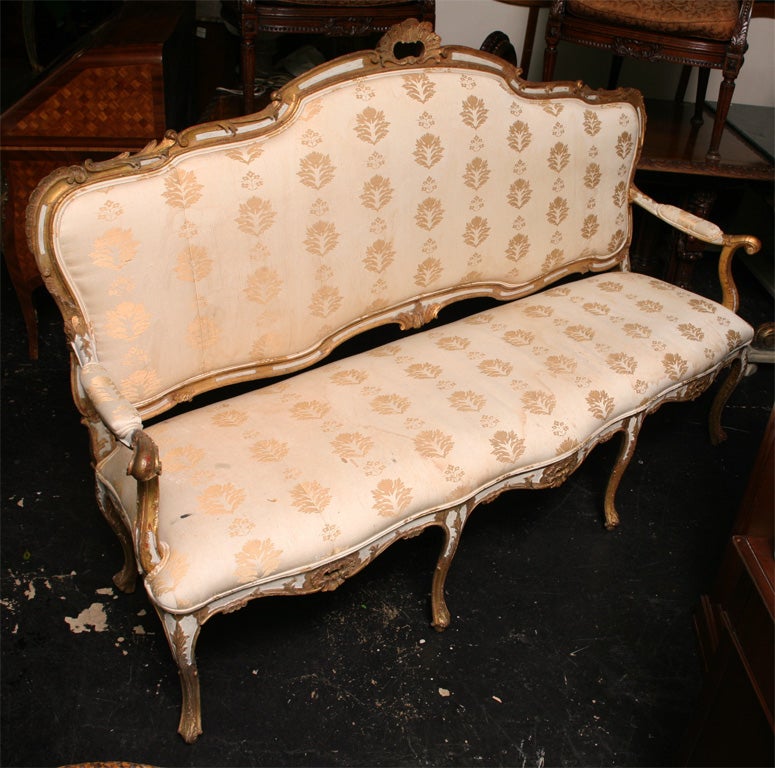 19th Century, Italian Sette, with scalloped reeded creast surmounted by a foliate carved cartouche, scrolled padded arms and serpentine seat rail with shell and rocaille carving raised on cabriole legs.