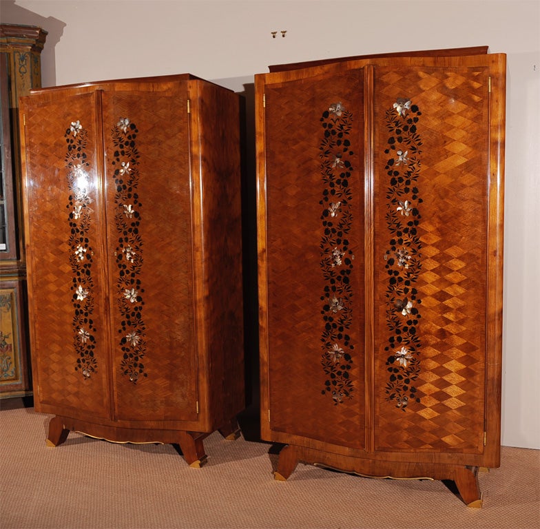 Pair of French Art Moderne armoires, mahogany with ebene de macassar and mother of pearl marquetry,bronze sabots and trim.  Interior outfitted with single mirror, pullout drawers and adjustable shelving.  Stamped by ebeniste that worked for Jules