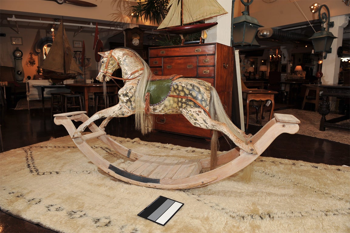 Very Large Scale Painted Rocking Horse; original patina, original horse hair mane and tail; original leather saddle; wonderfully expressive face; French circa 1860; some later repairs to the rocking base.