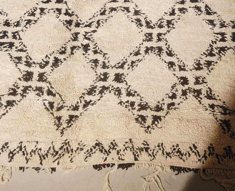 An impressive old-world style 100% hand loomed 11'x6' off-white Moroccan wool rug with fringe and dark brown/grey diamond pattern and border. Extra thick pile and off-white fringe on each end. Hand crafted by remote villagers in the Atlas Region.