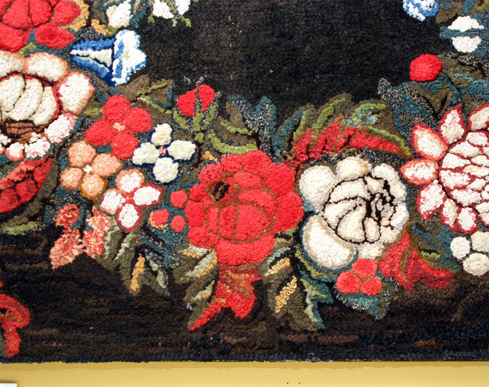 Oval wreath with cornucopias in vivid colors on black ground.  Illustrated in American Hooked and Sewn Rugs, Kopp, J and K, EP Dutton, 1975.  New York.  Found in Maine.