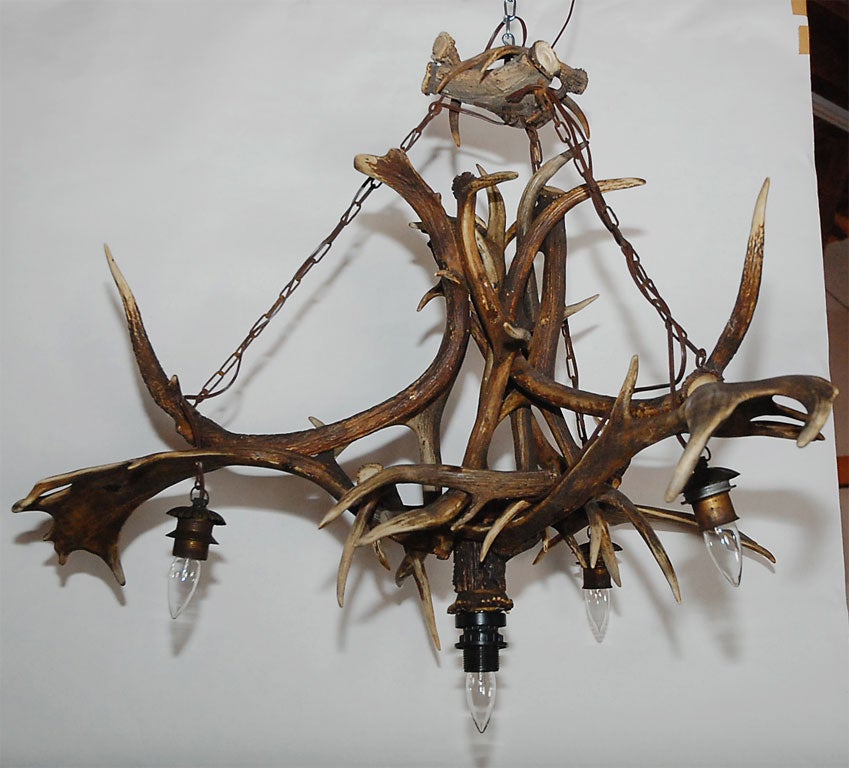 Possibly from Germany, this bold elk and deer horn four light chandelier will make a good impression in a variety of settings. Just picture it in your next project.