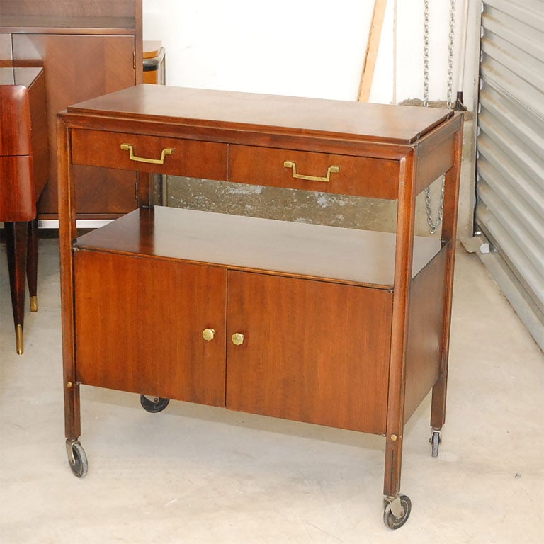 Unique mid-century bar cart by Gerry Zanck.  The wood inlayed top folds open for additional counter space.  Casters provide easily mobility while drawers, cabinet, and shelf provide ample storage.