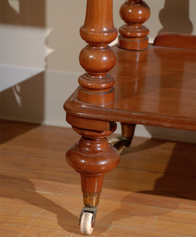 This is a lovely three tiered English Mahogany Trolley.  It is supported by casters.  The finials are in the 'onion' style.