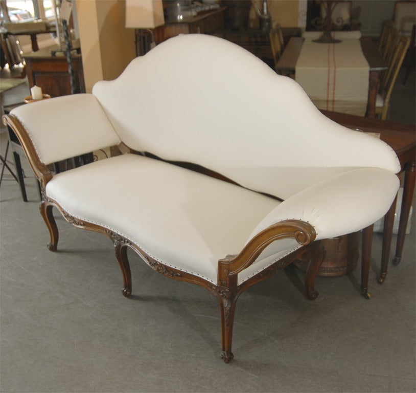 Dramatic walnut canapé, Italian Venetian style with French Louis XV style influences, circa 1890. Beautifully restrained hand-carving. Freshly reupholstered in white cotton.