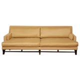 LONG MODERN SOFA WITH EBONIZED WOOD LEGS.