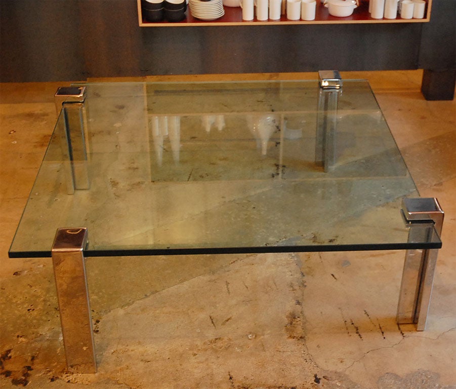 Squared thick glass coffee table with moveable legs.  Changing the position of the legs gives this table many alternatives for transitioning between table tops or aligning the legs to create a different look.