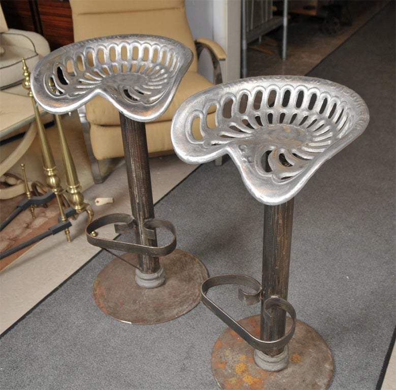 Pair of stools made from metal tractor seats in metal.