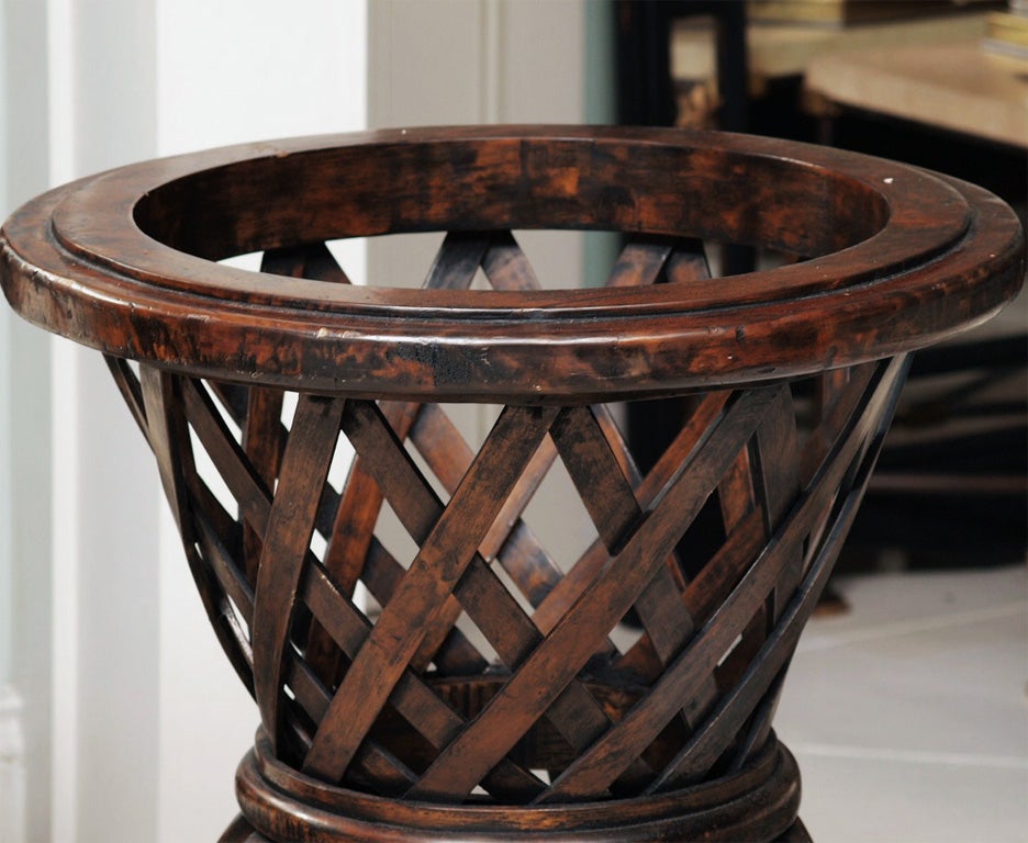 Two walnut-stained wooden urns; the turned framework supporting bentwood slats in classic urn form; interesting foliate detail at the base