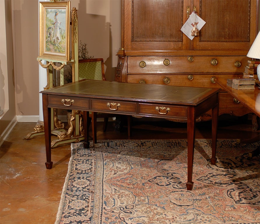 Vintage mahogany partner's desk made by the Trosby company out of reclaimed wood and veneers.  The desk has a nicely-worn, inset and tooled, green leather top.  The frieze contains three drawers on one side and three faux drawers on the other.  Each