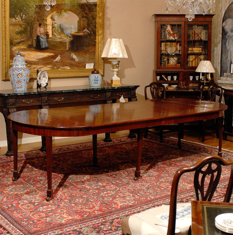 A beautiful 18th century dining table of solid mahogany with four leaves which were custom made later. The original leaves were of unfinished wood since they were covered with a tablecloth. The end pieces were used as demilune against the wall since