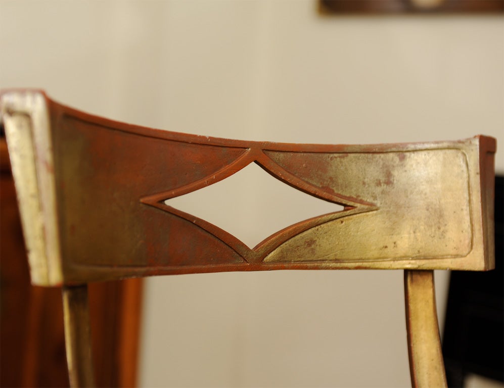A simple yet elegant gilt metal chair with graceful legs <br />
and a geometric detail on the back.