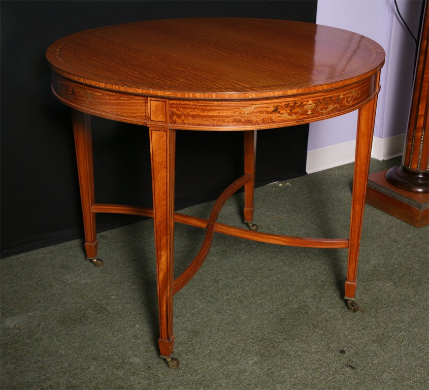 An Edwardian lamp or center table in satinwood with inlaid apron and crossbanding
