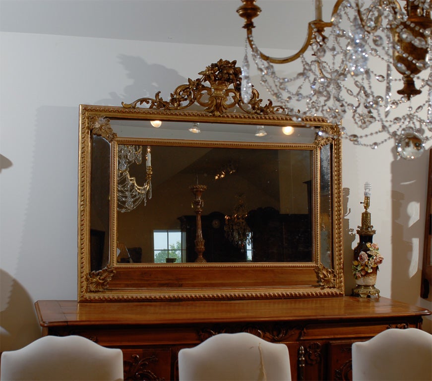 An Italian Rococo style giltwood pareclose mirror from the 19th century, with carved crest. Created in Italy during the 19th century, this horizontal pareclose mirror features a rectangular frame adorned with barley twist accents, topped with an