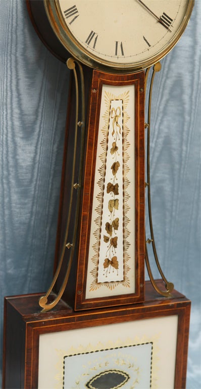 One of the loveliest clock designs to add style to your home. This Massachusetts banjo clock has elegant decorative extras such as upper and lower eglomise panels ( both replaced but the<br />
original damaged lower glass is included), original