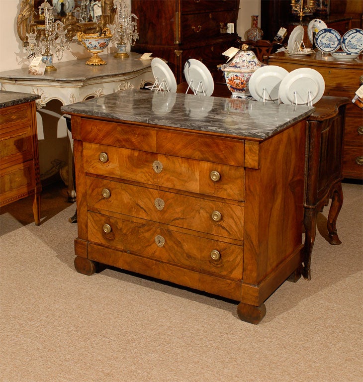 An Empire Period walnut commode with grey marble top and 4 drawers, originating in France during the first quarter of the 19th century.