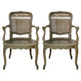 A Pair of Carved Louis XV Provincial Caned Fauteuils