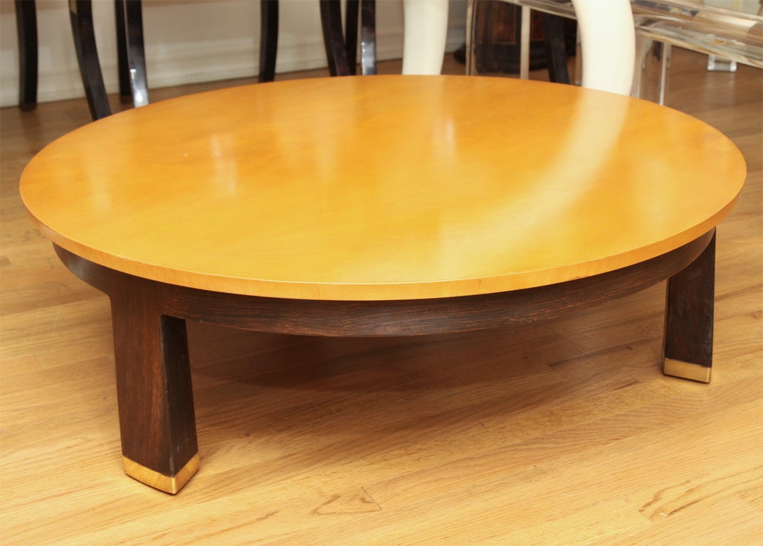 Circular blonde wood coffee table with ebonized wood base and brass detail by Dunbar.<br />
<br />
View our complete collection at www.johnsalibello.com