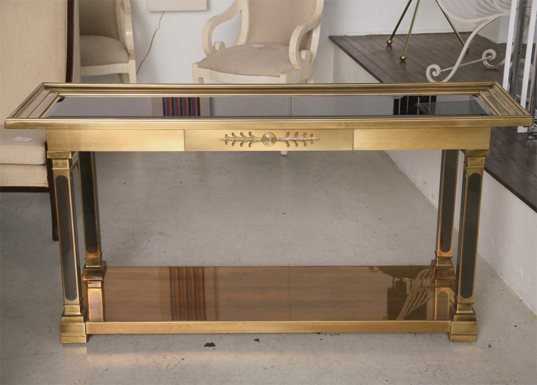 Mastercraft brass console with solid brass shelf and bevelled glass inset top. Neoclassical details enhance this modernist console.