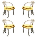 Four Lucite Curved Arm Chairs on Casters