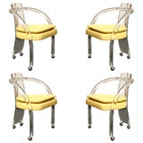 Four Lucite Curved Arm Chairs on Casters