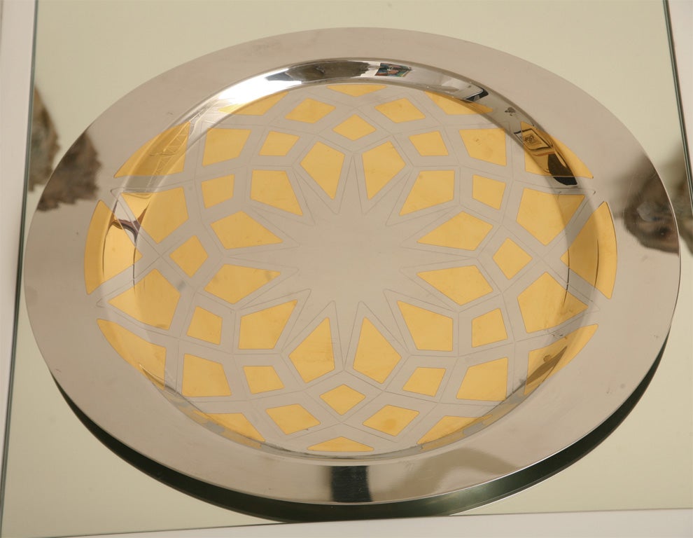 Serving tray fashioned of high polished steel and brass. Tray is oblong with wider rims on two sides for carrying. A jewel-like designed pattern.