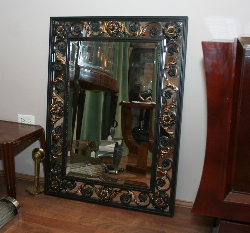 French Art Deco mirror attributed to Gilbert Poillerat in patinated wrought iron with gilt accents, circa 1940s.