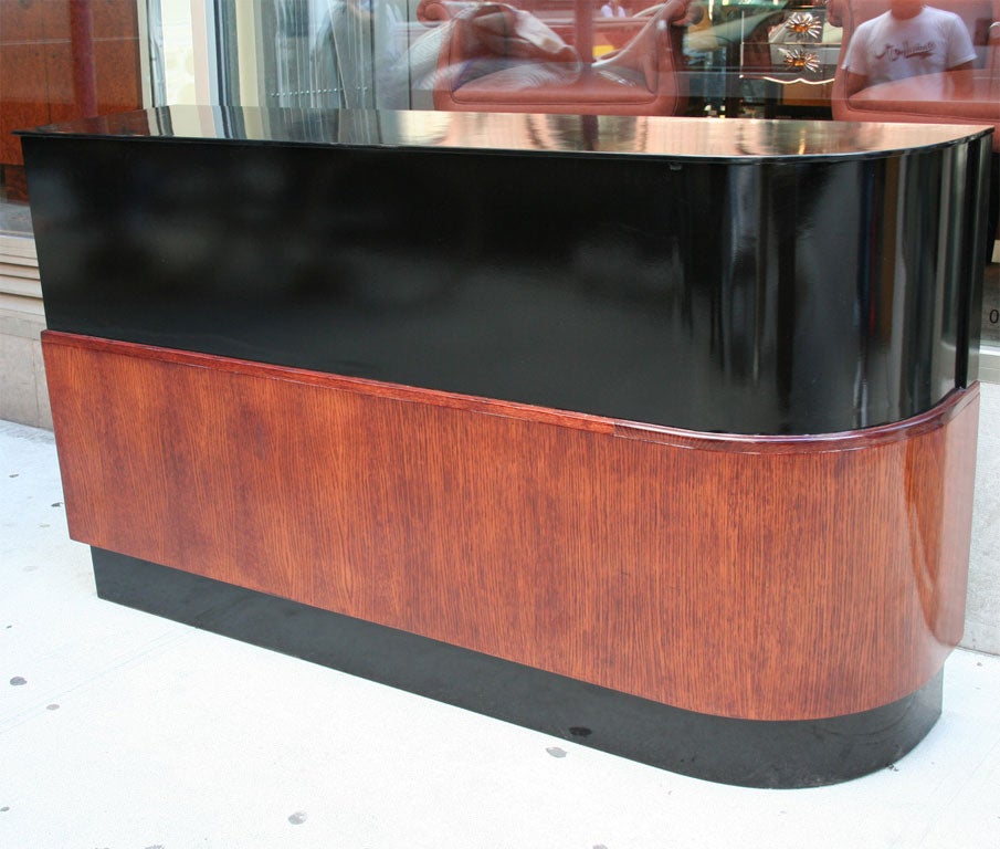 Machine Age dry bar/cabinet with<br />
streamline design, in walnut with<br />
black lacquered detailing. Back <br />
side has both sliding doors for <br />
storage, and an open display<br />
area.