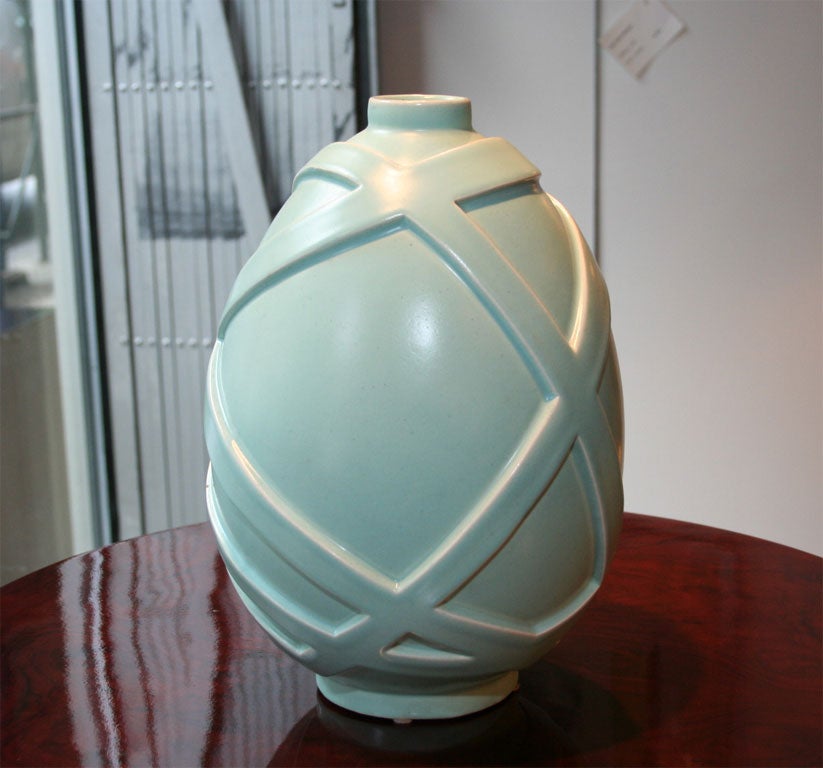 This special Art Deco ceramic vase features a relief banded geometric modernist banded detailing wrapping around the vase. It is executed in a matte glaze finish in celadon. This vase is signed Primavera on the bottom. It is a great addition to any