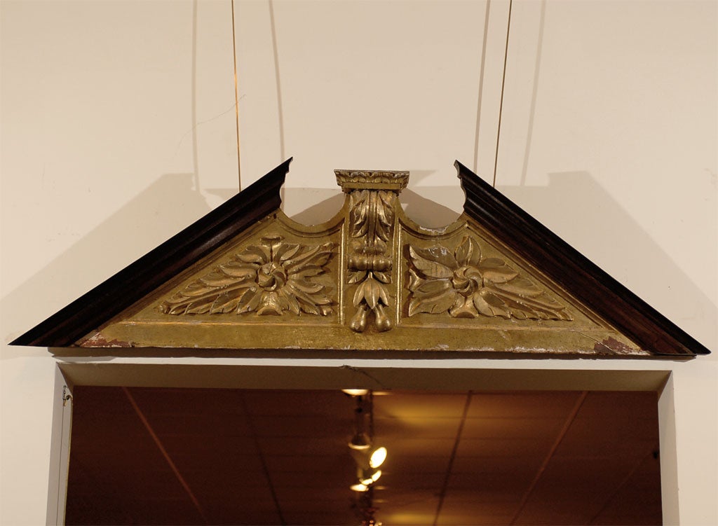 A large English gilt-wood and mahogany overdoor/pediment with acanthus leaves and pears, originating during the first half of the 19th century.
