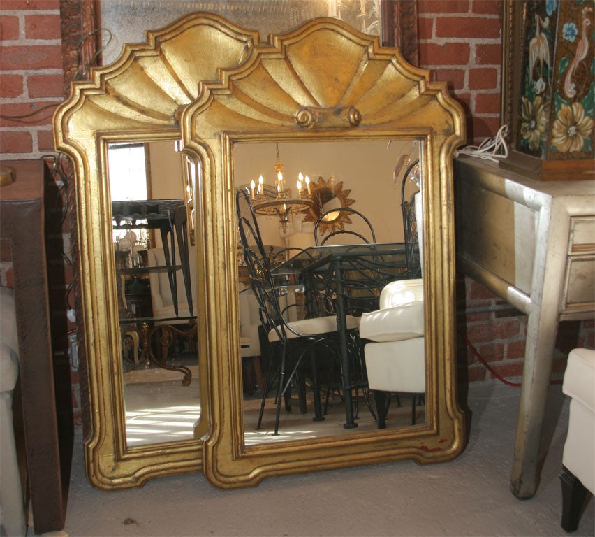 A pair gold leaf Dorothy Draper style carved shell mirrors.