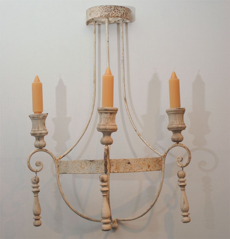 Pair of candle sconces with turned wood decorative elements.