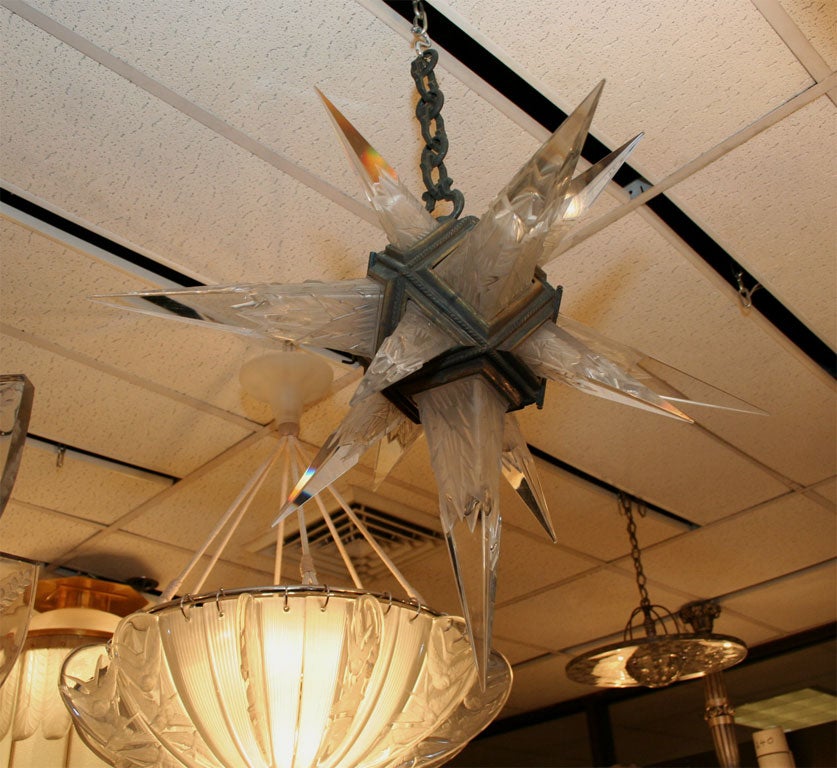 A star-shaped chandelier comprised of molded and etched glass diffusers, mounted in a bronze frame, produced in the 1930's for the American lighting retailer 