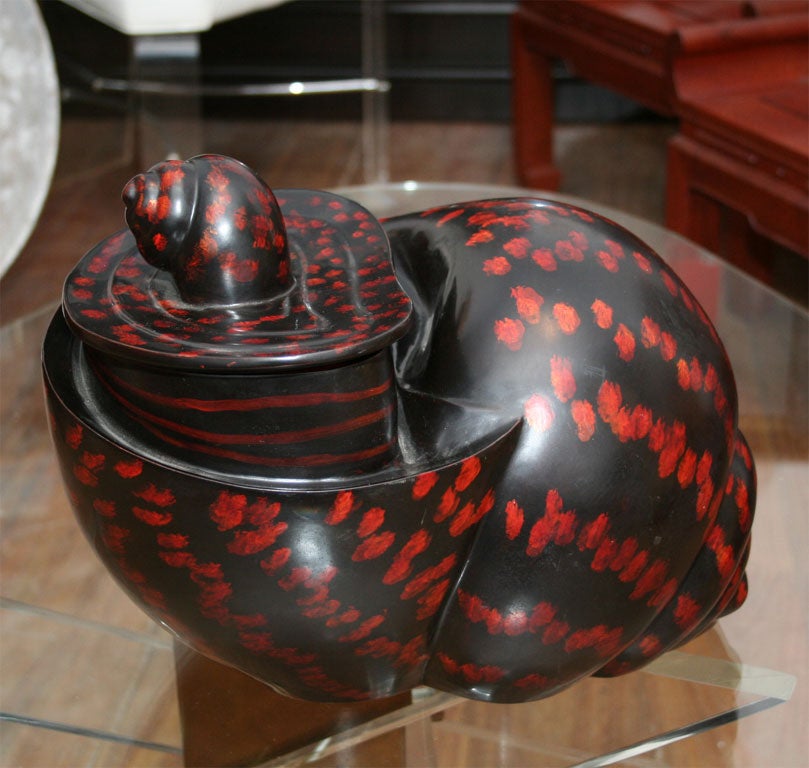 Indonesian snail shell shape box with lid,made from molded paper mache lacquered with dark brown background and orange spots.