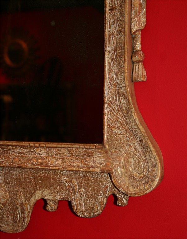 Very fine George II carved and gilt mirror with swan neck pediment flanking foliate carved cartouche over rectangular plate, the sides carved with drape and tassel decoration, over scrolled lower section with carved shell, the whole with punched,