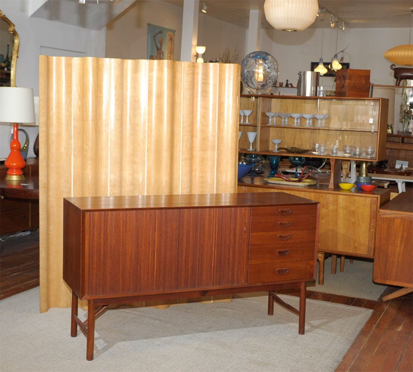 Beautiful teak dove-tail construction on this Peter Hvidt designed credenza. Single locking tambour door with adjustable shelf and four drawers. Completely restored.