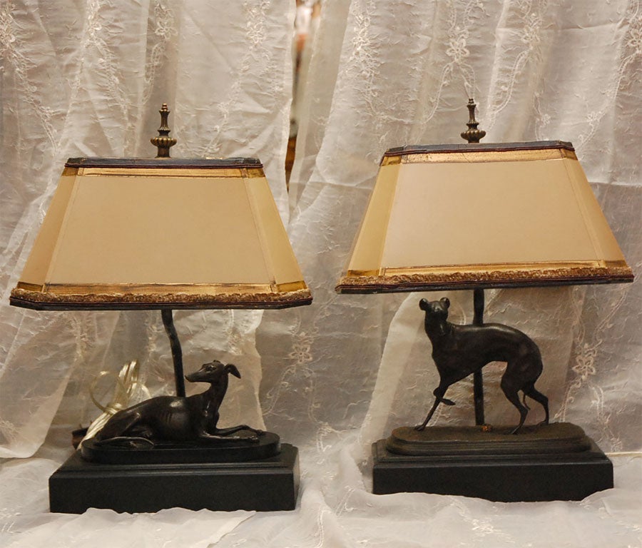 Pair of unique bronze Greyhound Dogs French mounted into lamps.  Small gold leaf detailed parchment shades with grey chenille and chocolate brown silk trim have been designed to augment these charming dog lamps. Purchased from a San Francisco estate