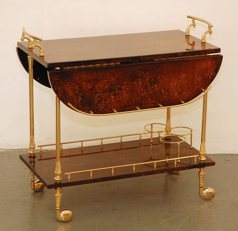 Aldo Tura  bar cart with goatskin leather and ornate brass  handles  and hardware.   Has fold  out leaf  extensions  for additional surface space and 3  bottle holders  on lower shelf.