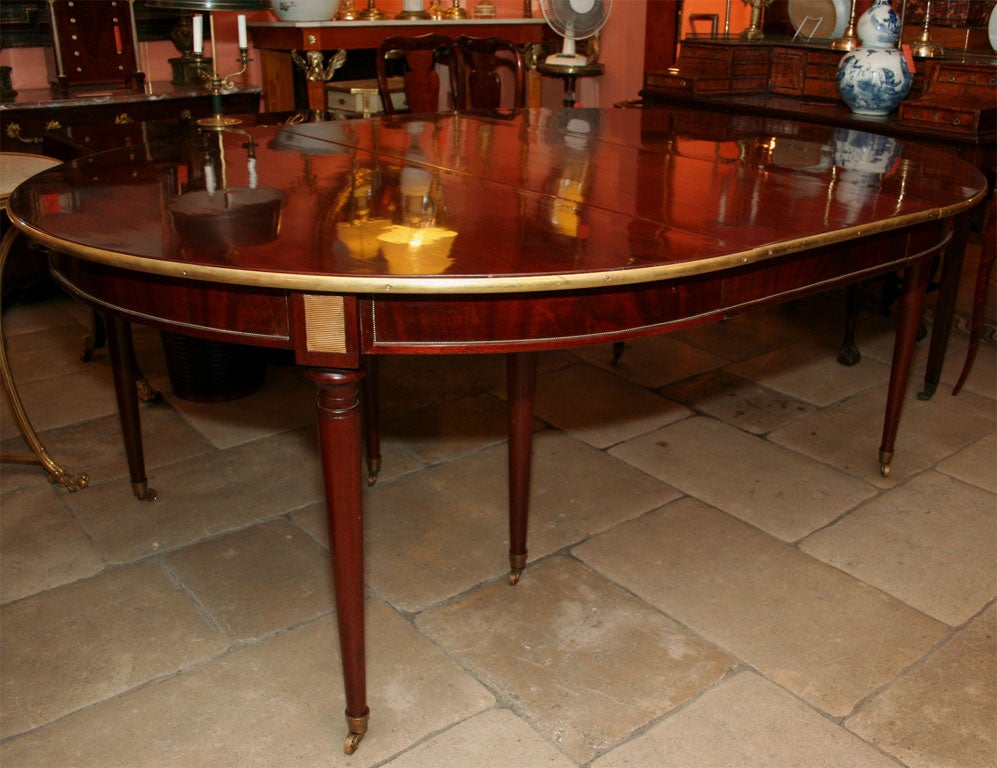 Large neo classic mahogany brass mounted extension dining table on turned legs and casters. with 5 leaves. width = 60 inches - 165 inches long