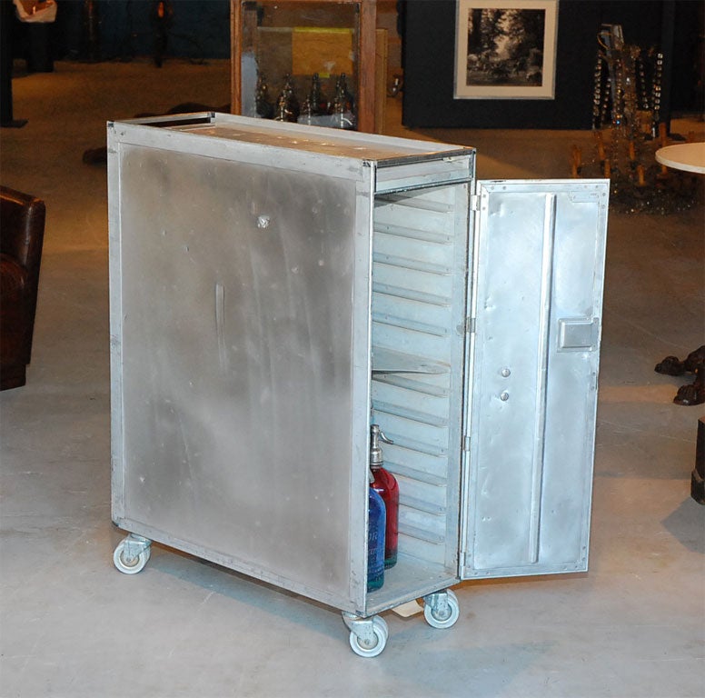 This is an original galley cart from a Continental airlines plane, circa 1950. It can still be used as a bar and would spice up any room or restaurant with its industrial feel. The size of the cart fits magazines perfectly and would work well if one